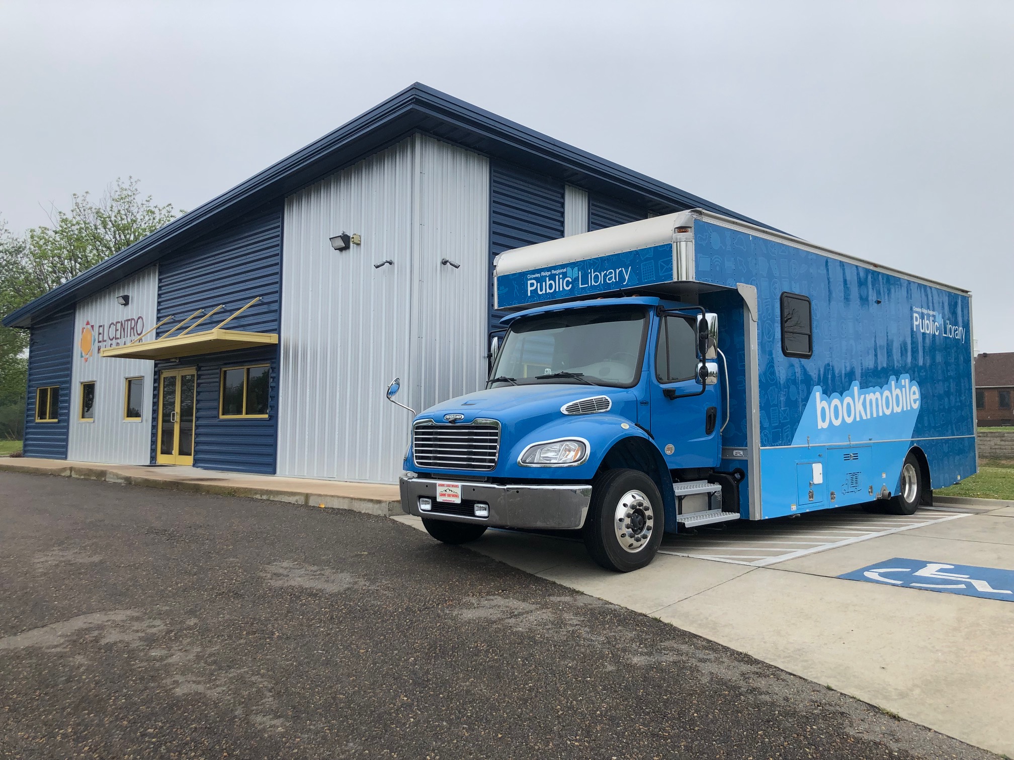 The Bookmobile, a large blue bus used as a traveling library, outside of the Jonesboro Hispanic Center
